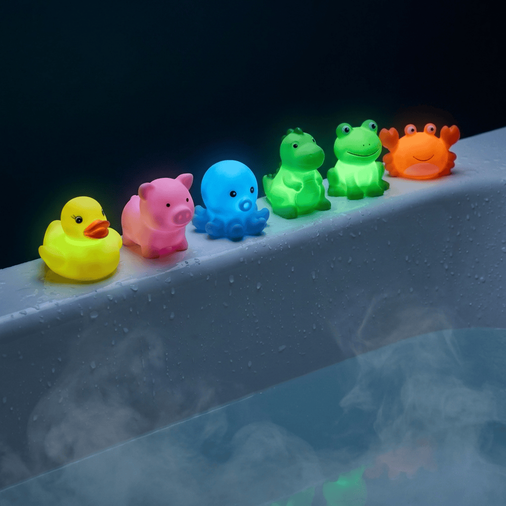 Kids bath bomb surprise toys glowing in the dark lined up on bathtub edge